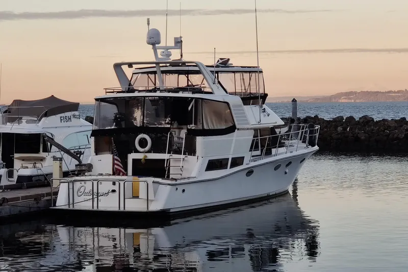 Outbound Yacht Photos Pics 1993 Symbol 55 Yachtfisher docked at sunset, reflecting on calm water.
