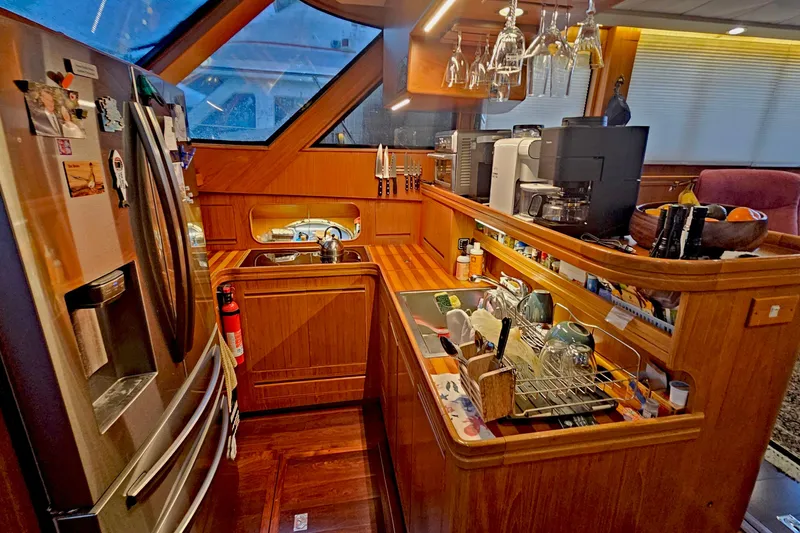 Outbound Yacht Photos Pics Luxurious kitchen interior of a 1993 Symbol 55 Yachtfisher, featuring modern appliances and wooden cabinetry.