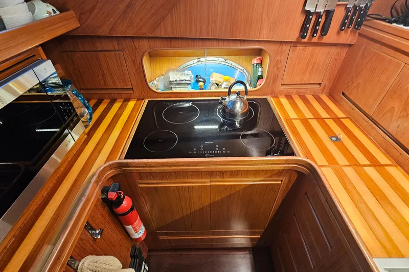 Outbound Yacht Photos Pics Wooden yacht kitchen with stove, kettle, and knives on a 1993 Symbol 55 Yachtfisher.