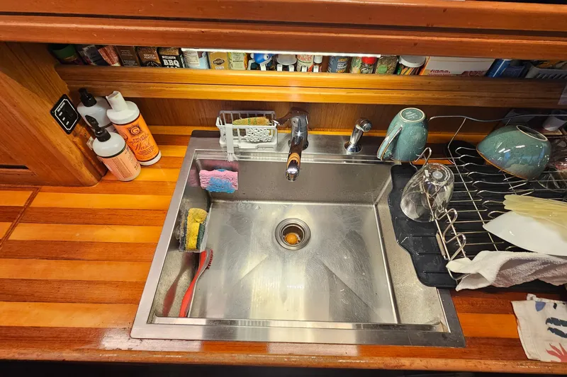 Outbound Yacht Photos Pics Kitchen sink area on a 1993 Symbol 55 Yachtfisher with wooden countertop and dish rack.