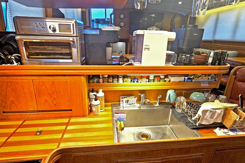 Outbound Yacht Photos Pics Galley kitchen in 1993 Symbol 55 Yachtfisher with appliances and wooden cabinetry.