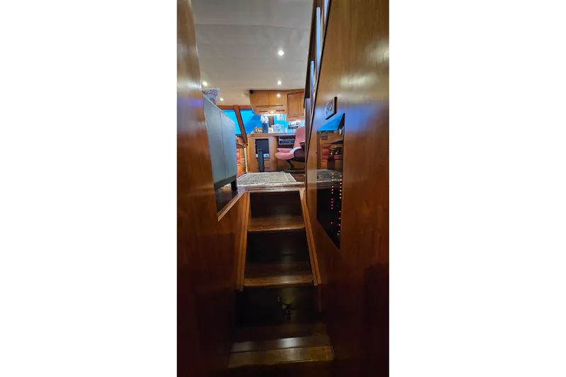 Outbound Yacht Photos Pics Interior view of 1993 Symbol 55 Yachtfisher, featuring wooden stairs and cozy cabin.