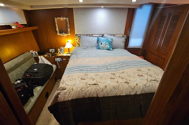 Outbound Yacht Photos Pics Cozy bedroom interior of 1993 Symbol 55 Yachtfisher with bed, pillows, and wooden decor.
