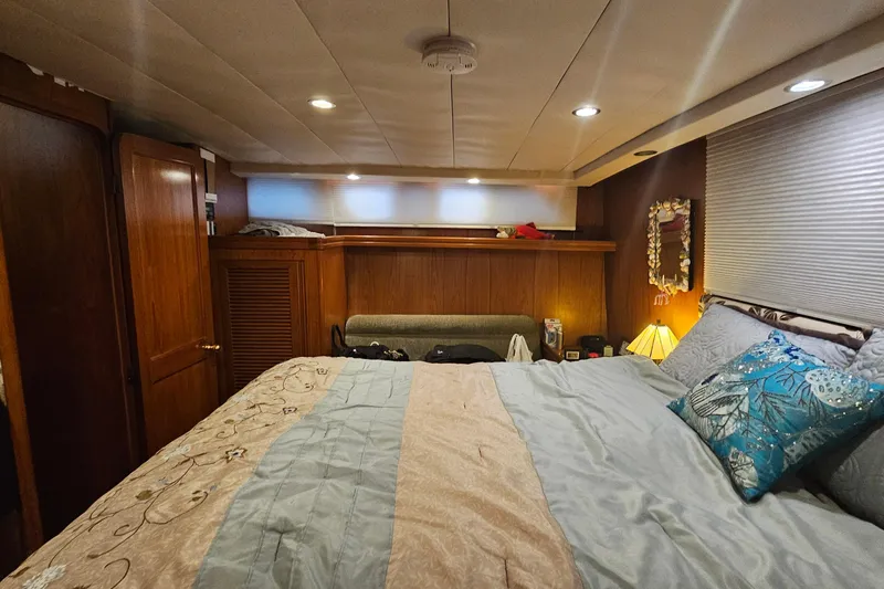 Outbound Yacht Photos Pics Luxurious bedroom interior of 1993 Symbol 55 Yachtfisher with cozy bedding and wooden accents.