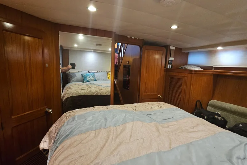 Outbound Yacht Photos Pics Cozy bedroom interior of 1993 Symbol 55 Yachtfisher with wood paneling and soft lighting.