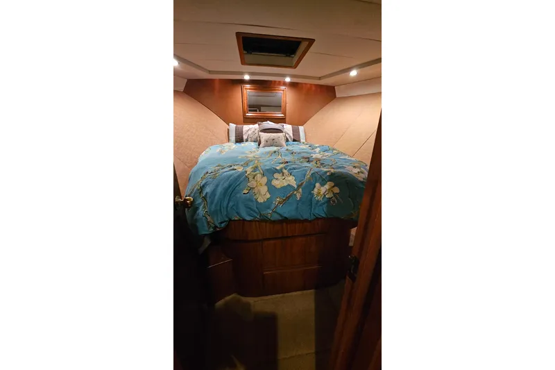 Outbound Yacht Photos Pics Cozy bedroom interior of 1993 Symbol 55 Yachtfisher with floral bedding and warm lighting.