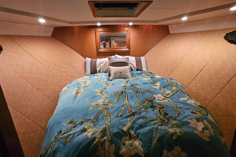Outbound Yacht Photos Pics Luxurious bedroom interior of 1993 Symbol 55 Yachtfisher with floral bedding and ambient lighting.