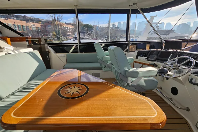Outbound Yacht Photos Pics 1993 Symbol 55 Yachtfisher interior with helm, seating, and wooden table, docked in marina.