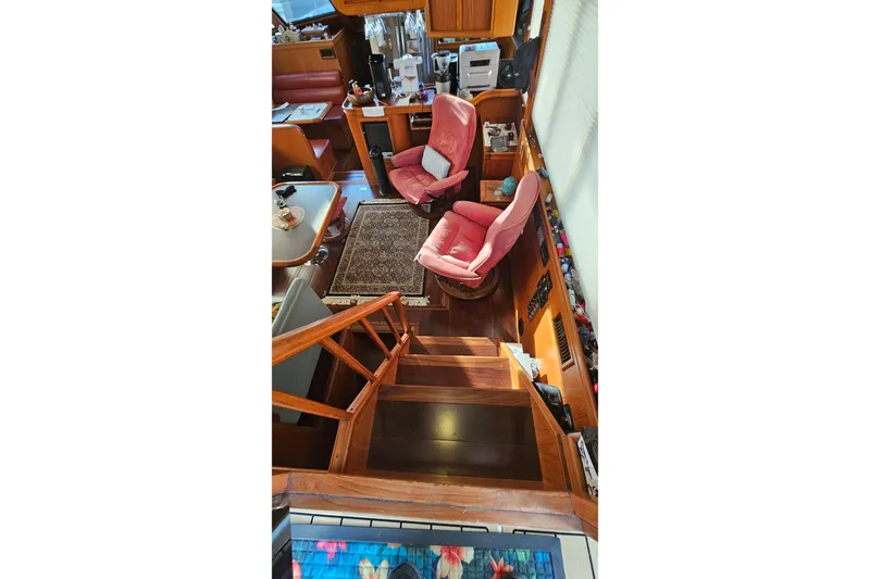 Outbound Yacht Photos Pics Interior of 1993 Symbol 55 Yachtfisher with wooden stairs and pink chairs.