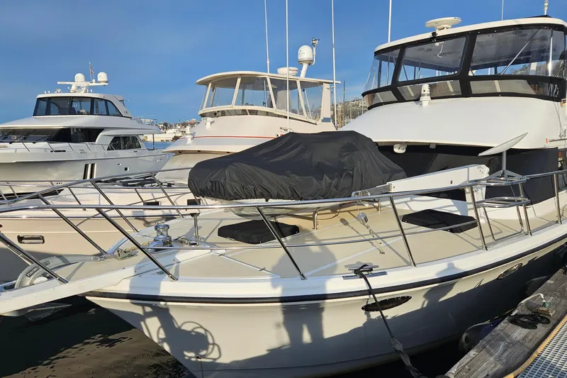 Outbound Yacht Photos Pics 1993 Symbol 55 Yachtfisher docked at marina, featuring sleek design and covered equipment.
