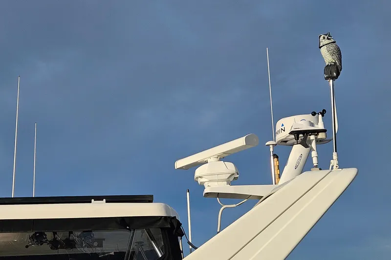 Outbound Yacht Photos Pics Radar and owl decoy on 1993 Symbol 55 Yachtfisher against blue sky.