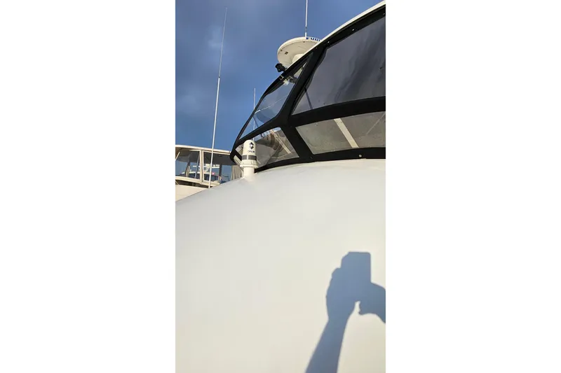 Outbound Yacht Photos Pics 1993 Symbol 55 Yachtfisher with radar and antennas under clear blue sky.