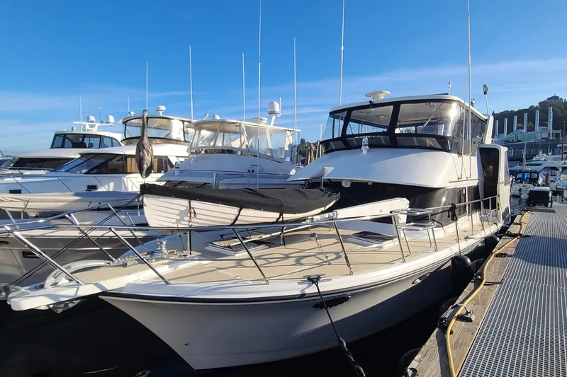Outbound Yacht Photos Pics 1993 Symbol 55 Yachtfisher docked at marina under clear blue sky.