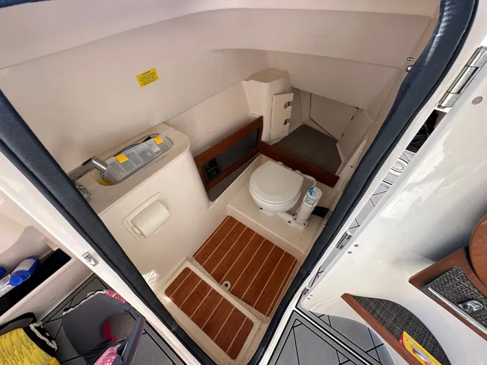  Yacht Photos Pics 2022 Grady-White Freedom 285 boat interior with compact bathroom and wooden flooring.