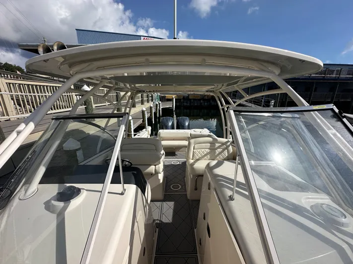  Yacht Photos Pics 2022 Grady-White Freedom 285 boat interior with seating and helm, docked under clear skies.