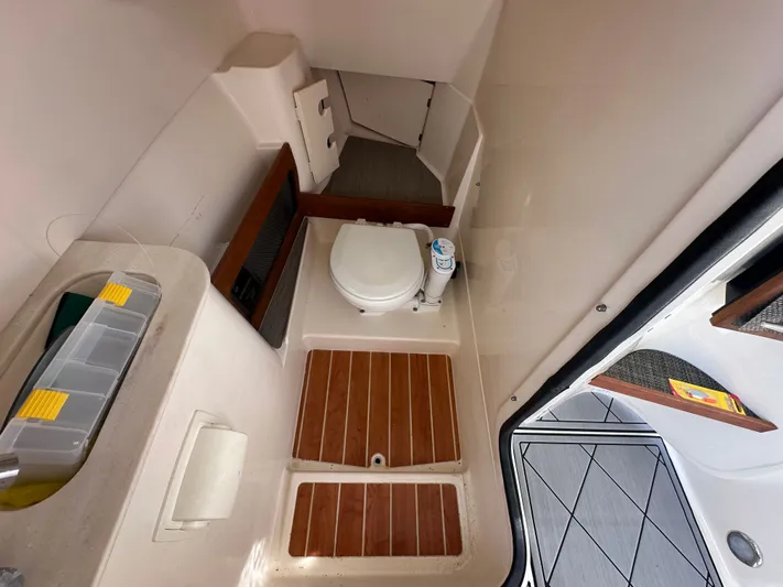  Yacht Photos Pics 2022 Grady-White Freedom 285 boat interior with compact bathroom and wooden flooring.