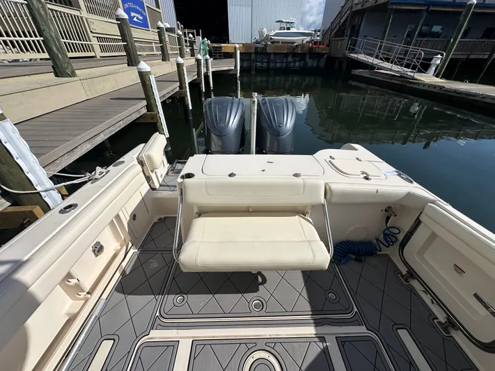  Yacht Photos Pics 2022 Grady-White Freedom 285 boat interior with seating and twin engines at a dock.