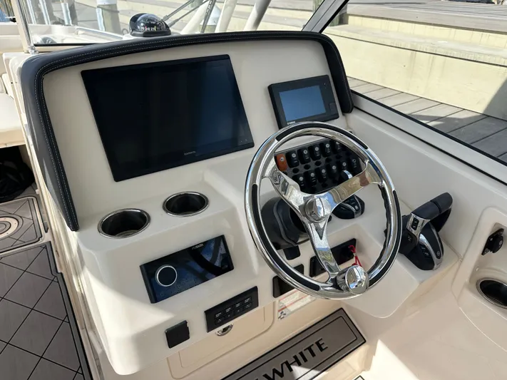 Yacht Photos Pics 2022 Grady-White Freedom 285 boat dashboard with steering wheel and electronic controls.