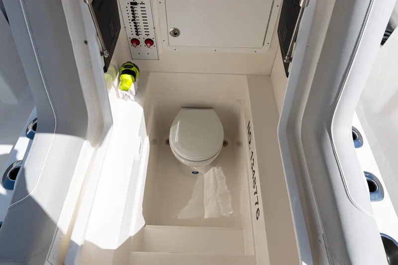  Yacht Photos Pics 2024 SeaVee 290B boat interior with compact marine toilet and control panel.