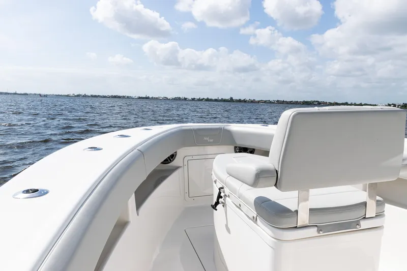  Yacht Photos Pics 2024 SeaVee 290B boat, white seating, ocean view, partly cloudy sky.