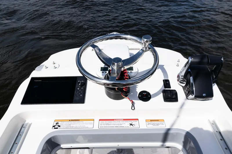  Yacht Photos Pics 2024 SeaVee 290B boat helm with steering wheel and controls on water.