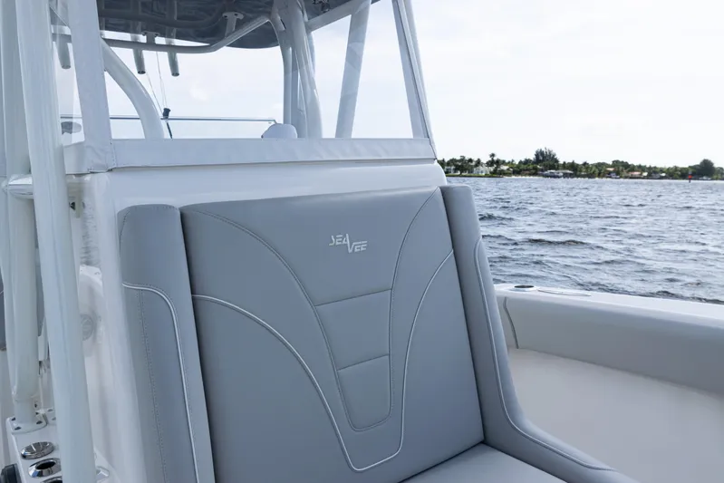  Yacht Photos Pics 2024 SeaVee 290B boat interior with gray seating, on a calm ocean backdrop.