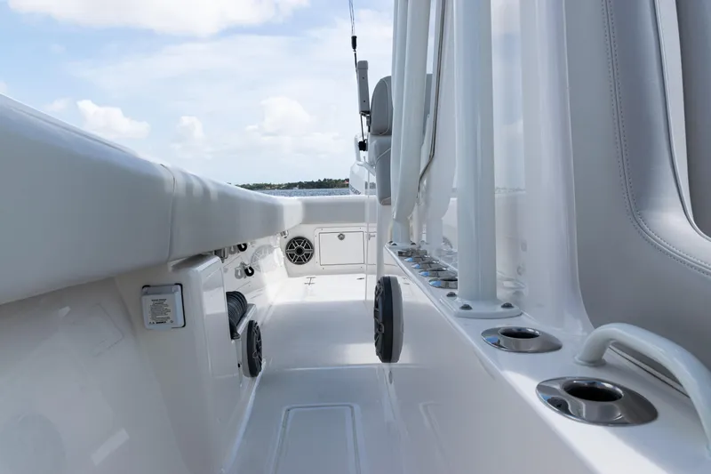  Yacht Photos Pics 2024 SeaVee 290B boat deck with rod holders and seating, under a clear sky.