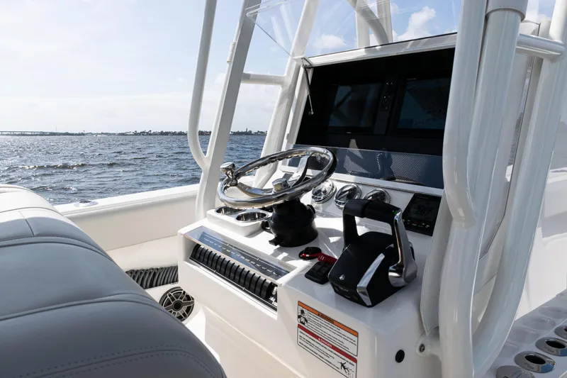  Yacht Photos Pics 2024 SeaVee 290B boat console with steering wheel and controls, on open water.