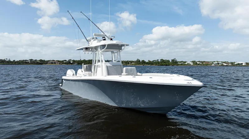  Yacht Photos Pics 2024 SeaVee 290B boat on calm water under a partly cloudy sky.