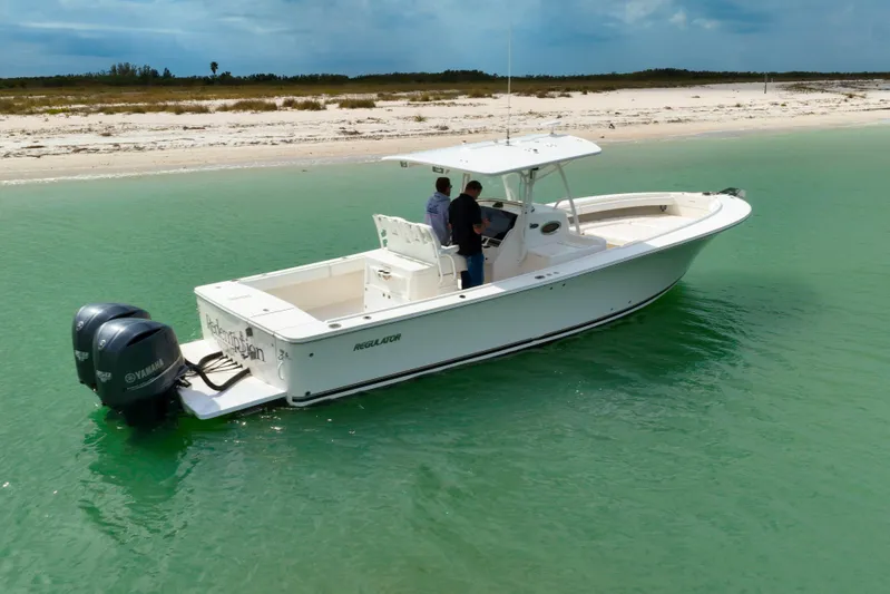 Redemption Yacht Photos Pics 2012 Regulator 34SS boat with Yamaha engines on turquoise water near sandy beach.