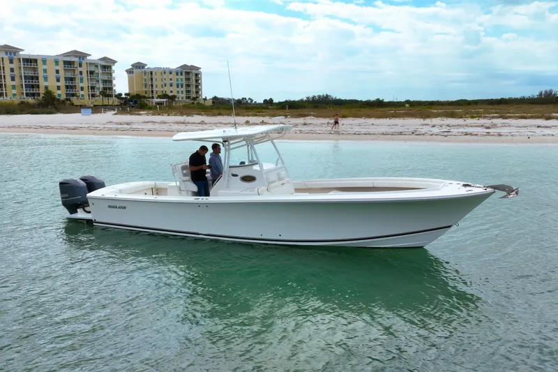 Redemption Yacht Photos Pics 2012 Regulator 34SS boat on calm water near a sandy beach and buildings.