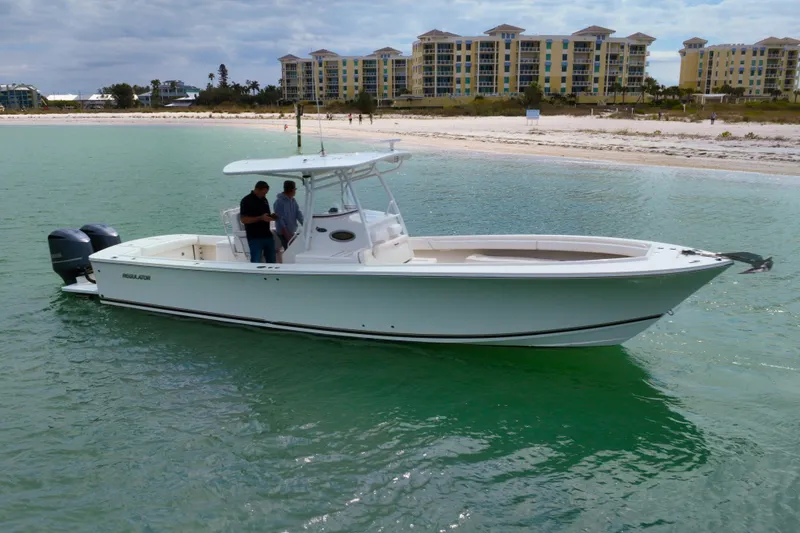 Redemption Yacht Photos Pics 2012 Regulator 34SS boat on calm water near a sandy beach.