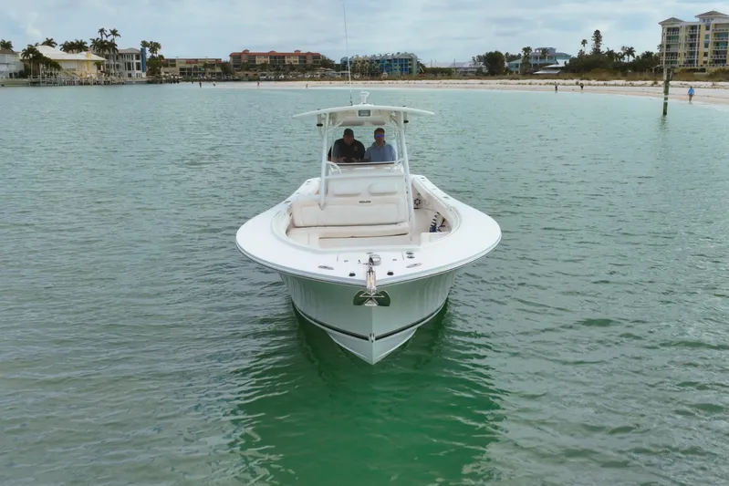 Redemption Yacht Photos Pics 2012 Regulator 34SS boat on calm water near a sandy beach.