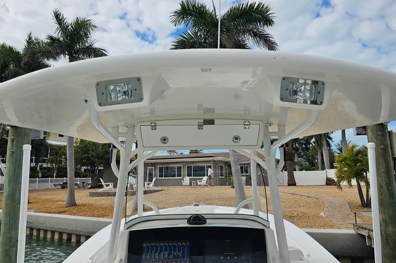 Redemption Yacht Photos Pics 2012 Regulator 34SS boat with T-top and electronics, docked near tropical landscape.