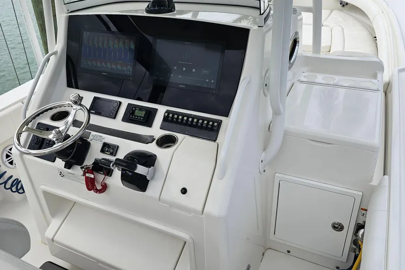Redemption Yacht Photos Pics Control panel of a 2012 Regulator 34SS boat with steering wheel and displays.