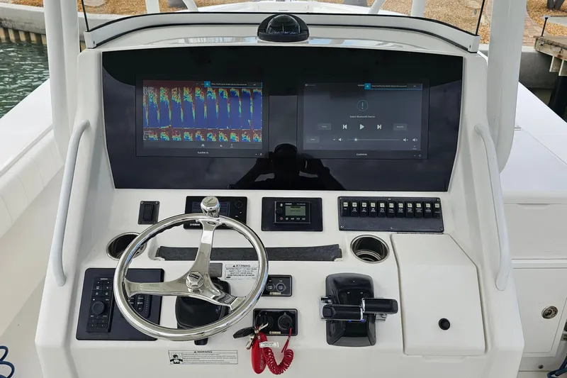 Redemption Yacht Photos Pics Control panel of a 2012 Regulator 34SS boat with dual screens and steering wheel.