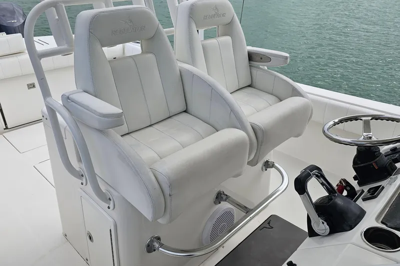Redemption Yacht Photos Pics 2012 Regulator 34SS boat helm with dual white captain's chairs and steering wheel.