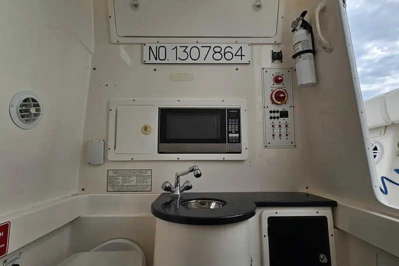 Redemption Yacht Photos Pics 2012 Regulator 34SS boat interior with microwave, sink, and control panel.