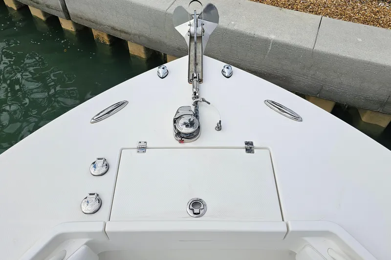 Redemption Yacht Photos Pics Bow of 2012 Regulator 34SS boat with anchor and hatch, docked by concrete wall.