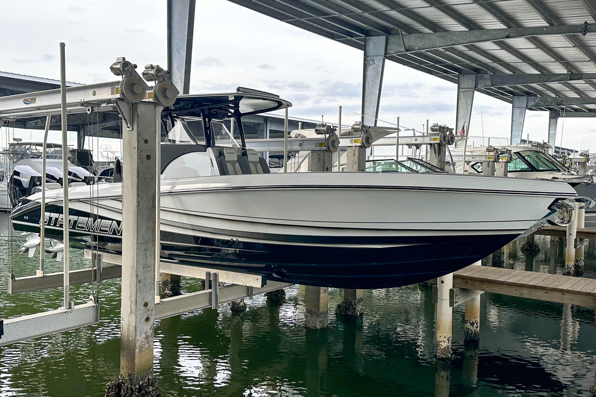 2024 Statement 350 Open boat on lift in marina under metal roof.