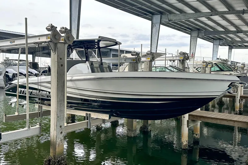  Yacht Photos Pics 2024 Statement 350 Open boat on lift in marina under metal roof.