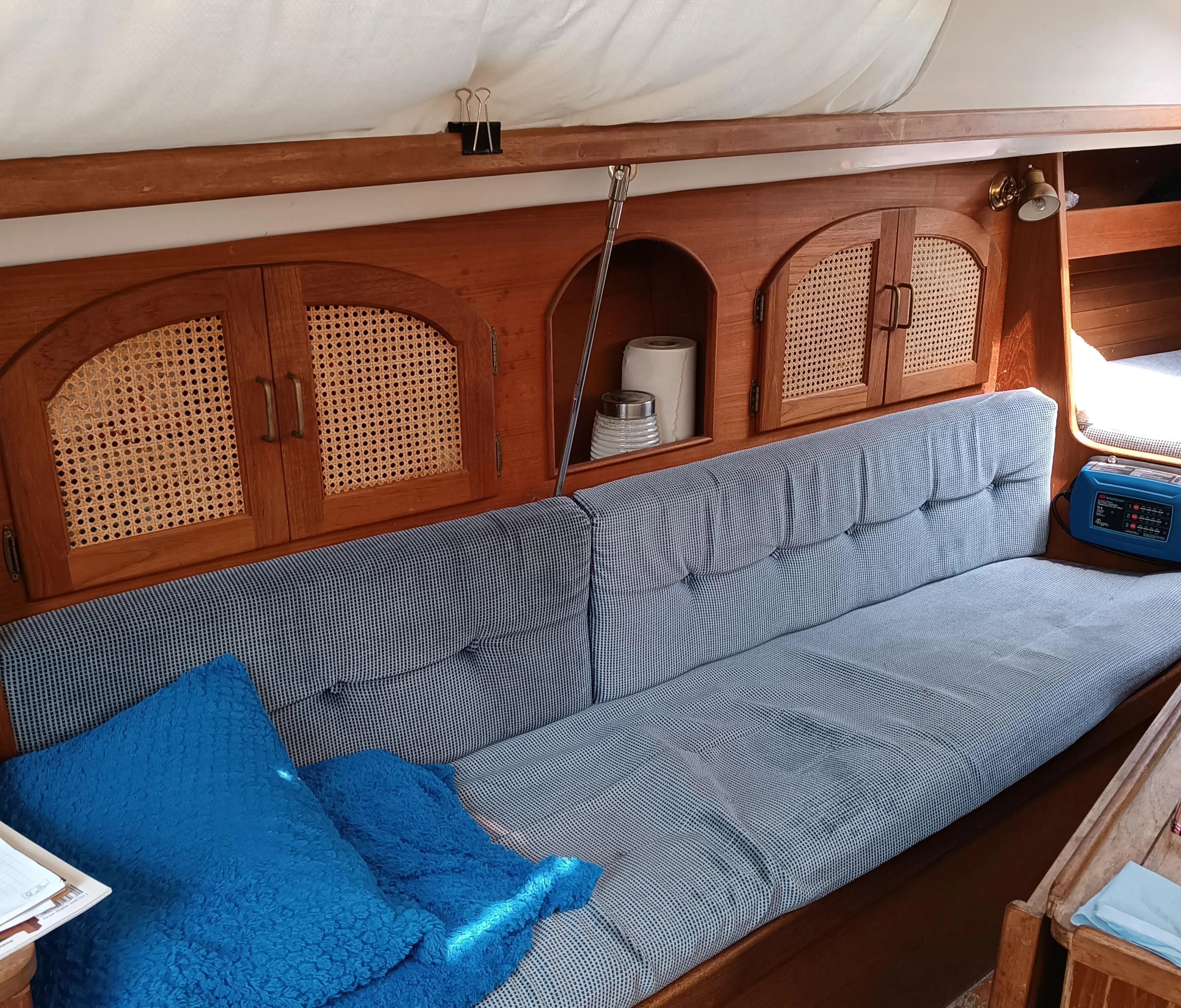 Interior of 1988 Aloha 30 sailboat with cozy seating and wooden cabinetry.