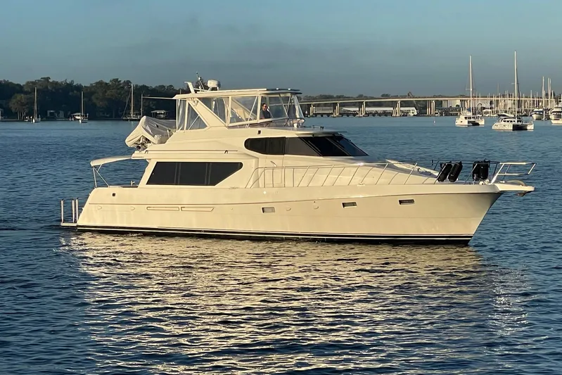 Aventis Yacht Photos Pics 1999 McKinna 57 Pilothouse yacht cruising on calm waters near a marina.
