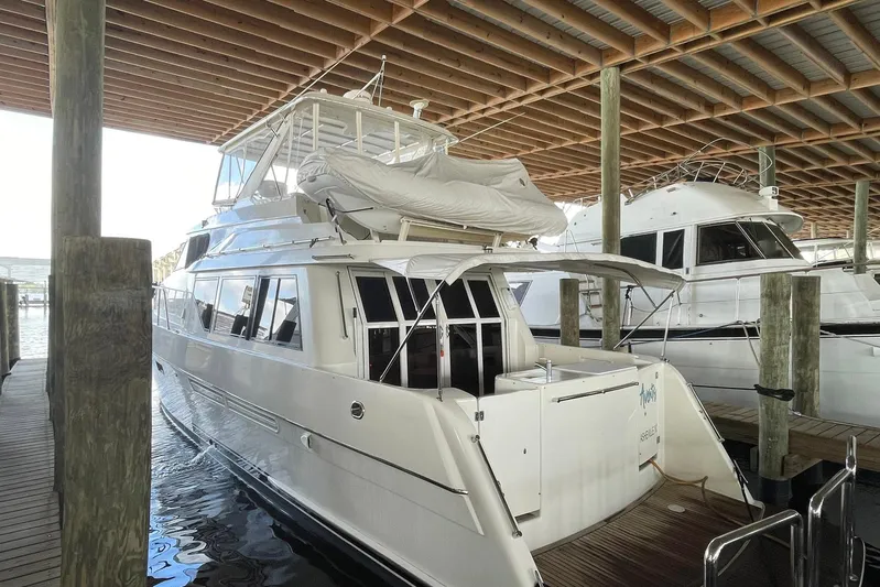 Aventis Yacht Photos Pics 1999 McKinna 57 Pilothouse yacht docked under a wooden canopy.
