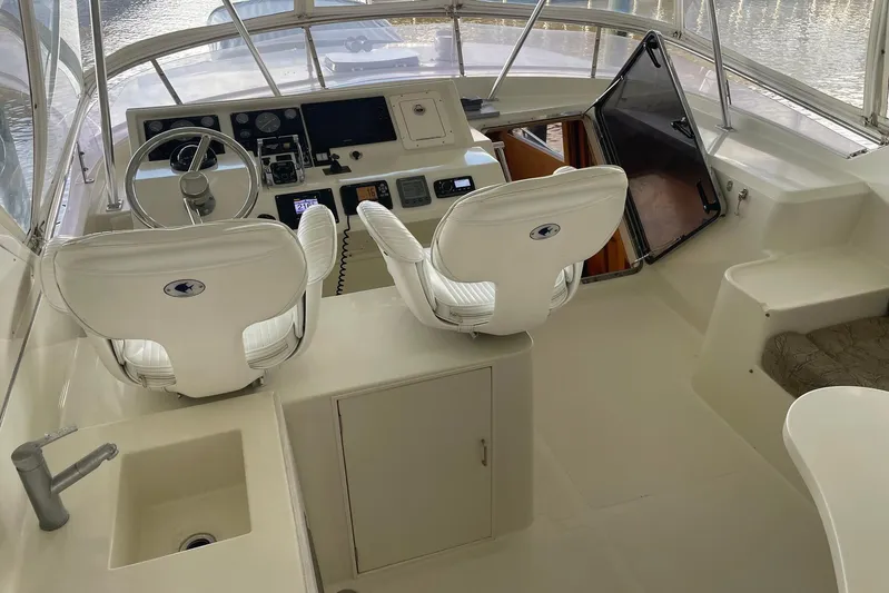Aventis Yacht Photos Pics 1999 McKinna 57 Pilothouse yacht interior with helm, white seats, and control panel.
