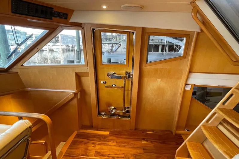 Aventis Yacht Photos Pics Interior of 1999 McKinna 57 Pilothouse yacht with wooden finishes and dockside view.