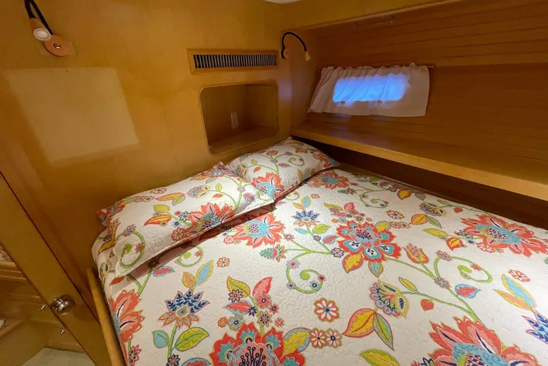 Aventis Yacht Photos Pics Cozy bedroom in 1999 McKinna 57 Pilothouse with floral bedding and wooden interior.
