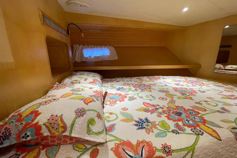 Aventis Yacht Photos Pics Cozy cabin interior of 1999 McKinna 57 Pilothouse with floral bedding and wooden accents.