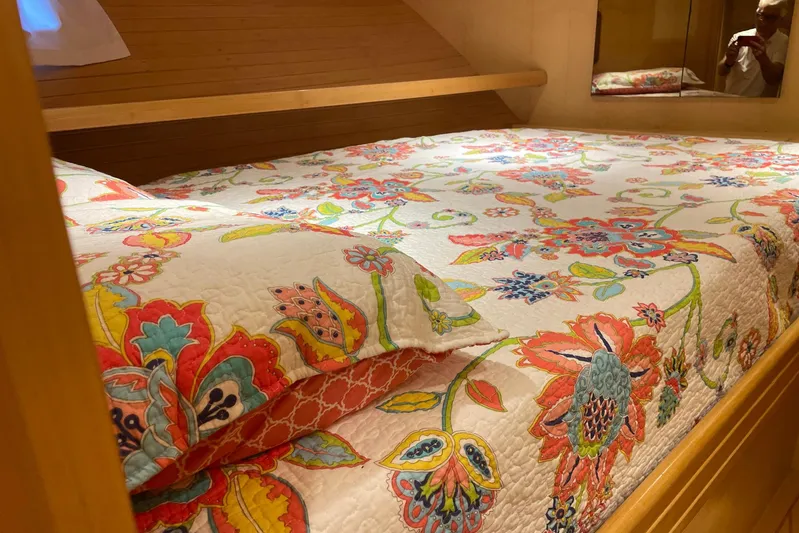 Aventis Yacht Photos Pics Floral-patterned bedding in 1999 McKinna 57 Pilothouse cabin, featuring warm wood accents.