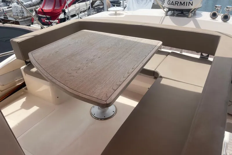  Yacht Photos Pics Luxury seating area on 2020 Cayman Yachts S520 with wooden table and cushioned benches.